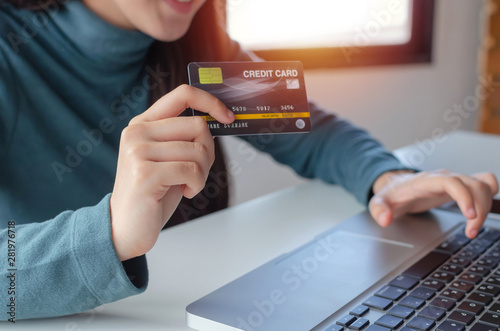 young woman entering security code with laptop computer and paying credit card on desk at home office, internet network technology, electronic online booking, payment and shopping online concept