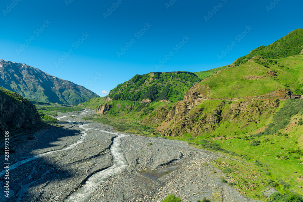 Blue sky over the high scenic Caucasus Mountains in Georgia on the Georgian Military Highway