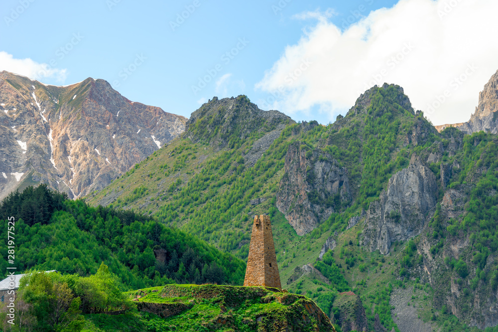 High traditional tower of Georgia on the background of high mountains of the Caucasus