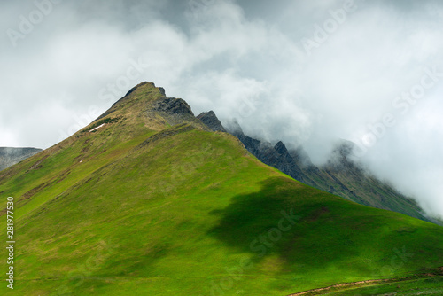 High green hill on a background of clouds in the summer day, Caucasus in June
