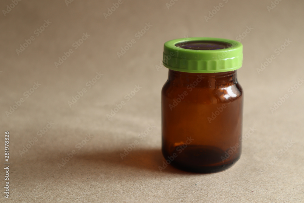 Brown chicken soup drink bottle, green lid on brown background Brown chicken soup drink bottle, green lid on brown background