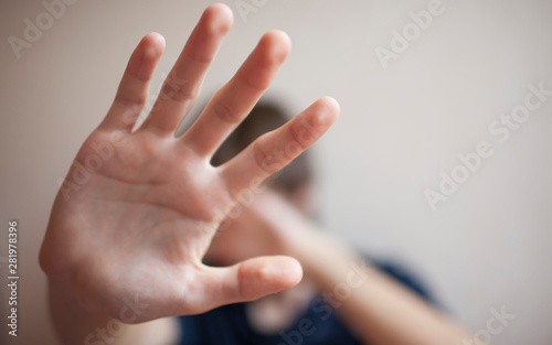 Teen boy protects himself with open palm