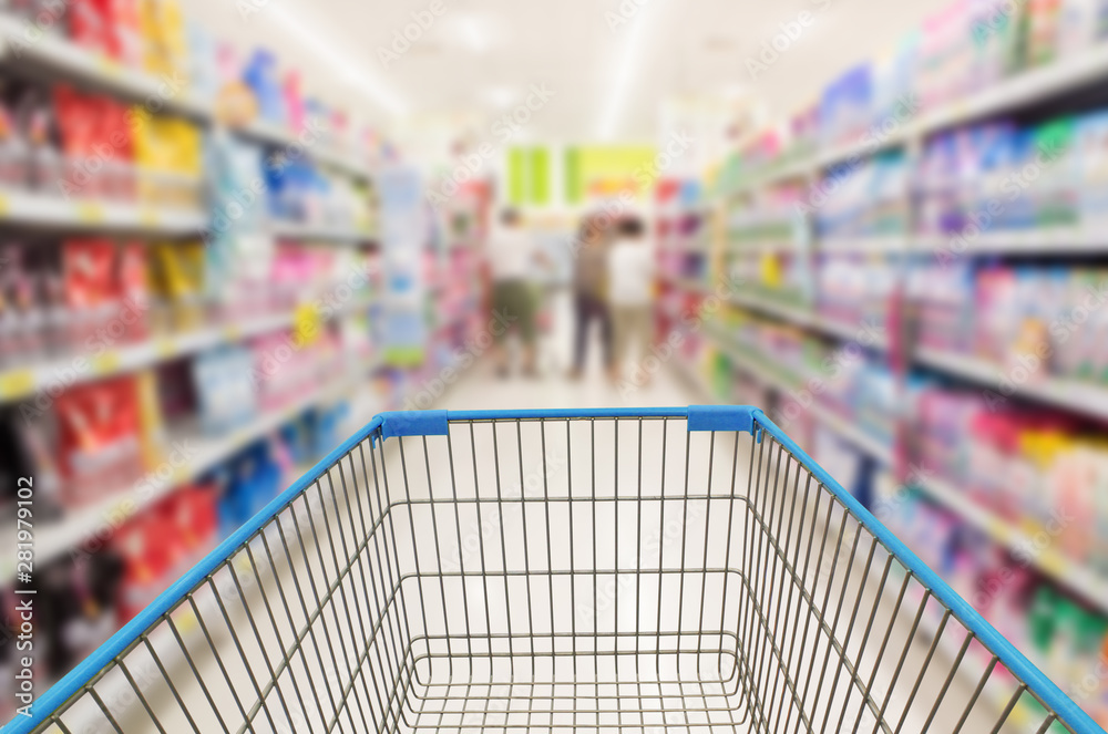 shopping cart in supermarket aisle with product shelves interior defocused blur background