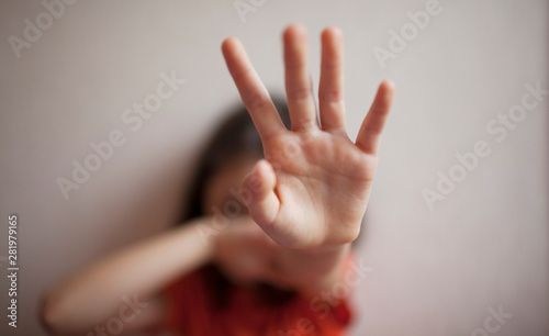 Little girl protects herself with her hand