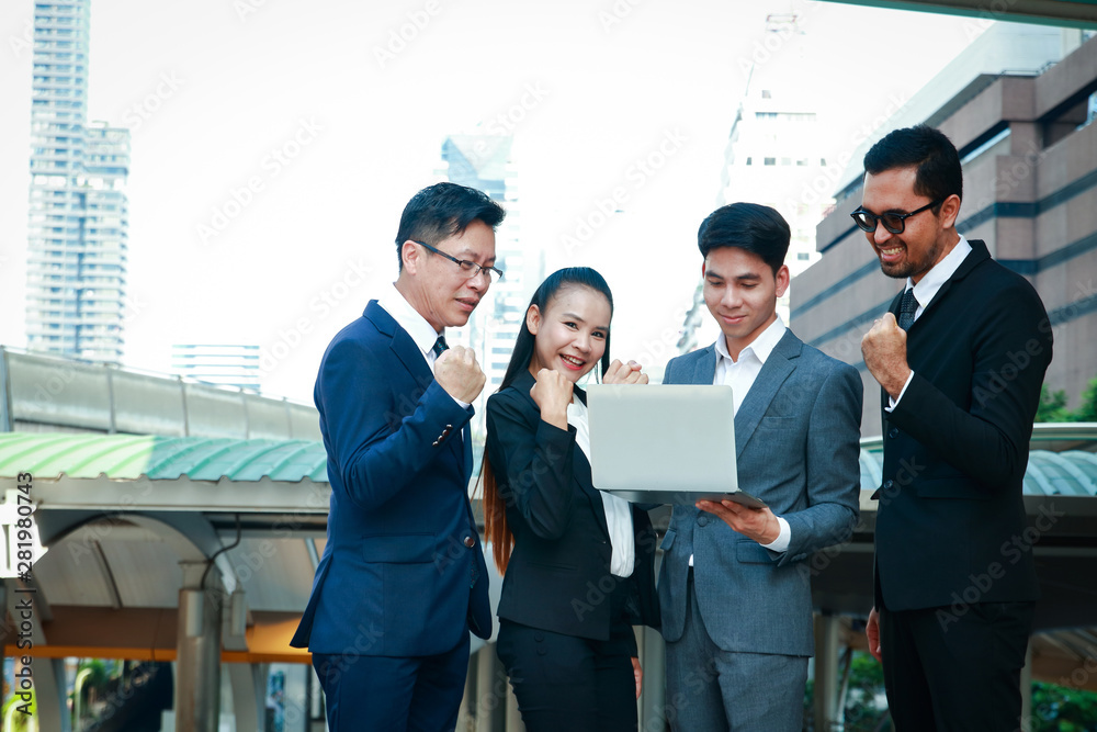 Businessmen, men and women Hold the notebook, raise arms, be happy, work successfully Businessmen, men and women Hold the notebook, raise arms, be happy, work successfully