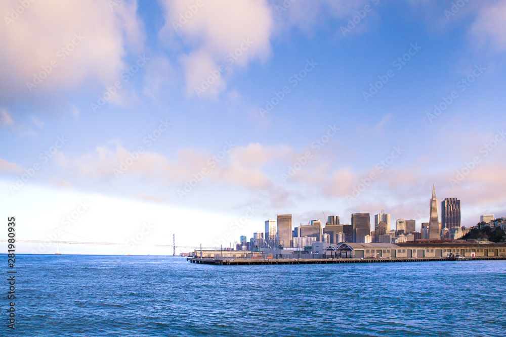 City of San Francisco California seen from the Bay with Bay Bridge, docks and buildings of skyline in view.