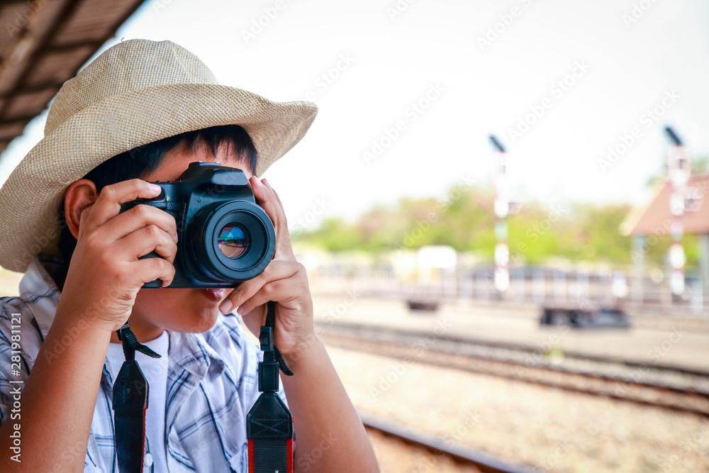 Asian children are taking pictures with a DSLR. Travel by train.
