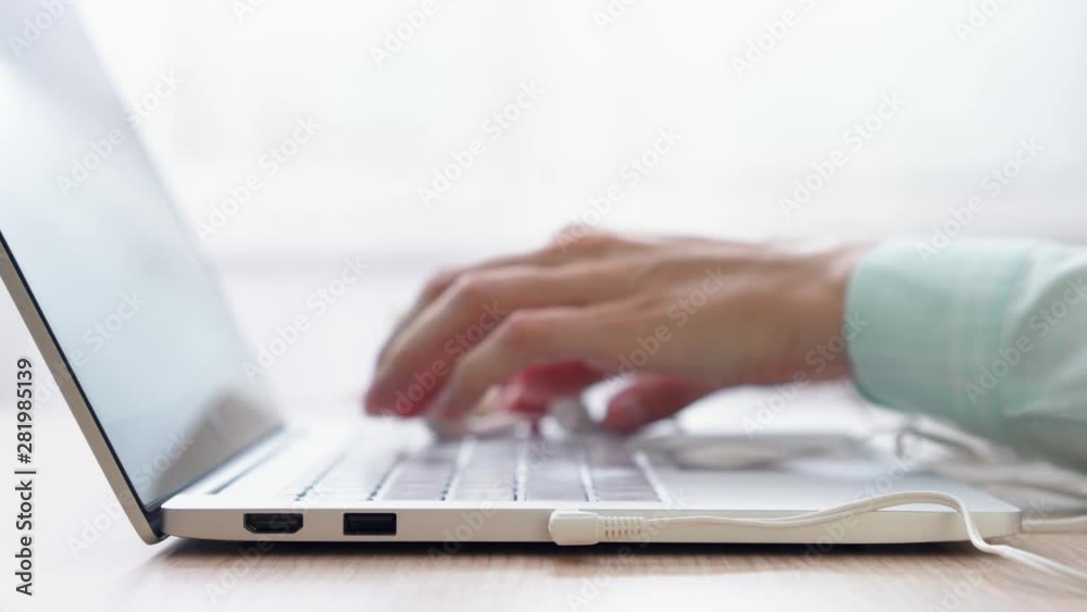 Woman freelancer working on laptop at home-office. Close up of female hands connecting headphones to computer. Businesswoman plugging in earphones at work and listening to music. Dolly shot Woman freelancer working on laptop at home-office. Close up of female hands connecting headphones to computer. Businesswoman plugging in earphones at work and listening to music. Dolly shot