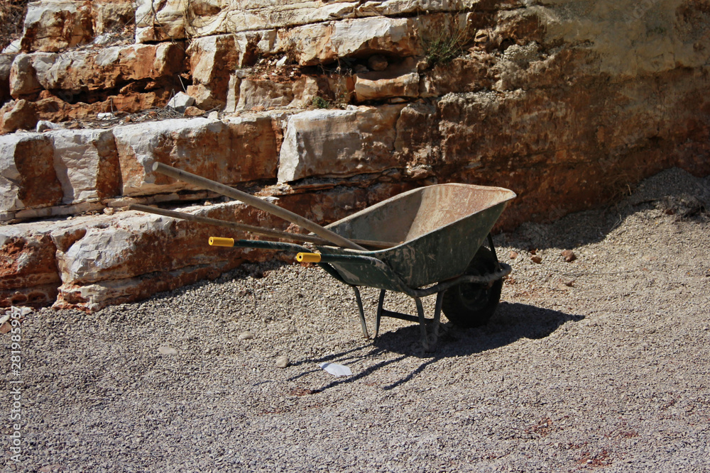 Empty construction car with tools near a stone rock Empty construction car with tools near a stone rock