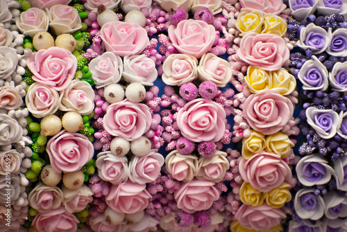 Bouquets of artificial flowers are sold at the fair. Corollas of colored small flowers. Closeup of national decorations and accessories for clothing.