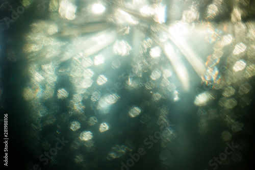 Easy to add lens flare effects for overlay designs or screen blending mode to make high-quality images. Abstract sun burst, digital flare, iridescent glare over black background. Drops on glass.