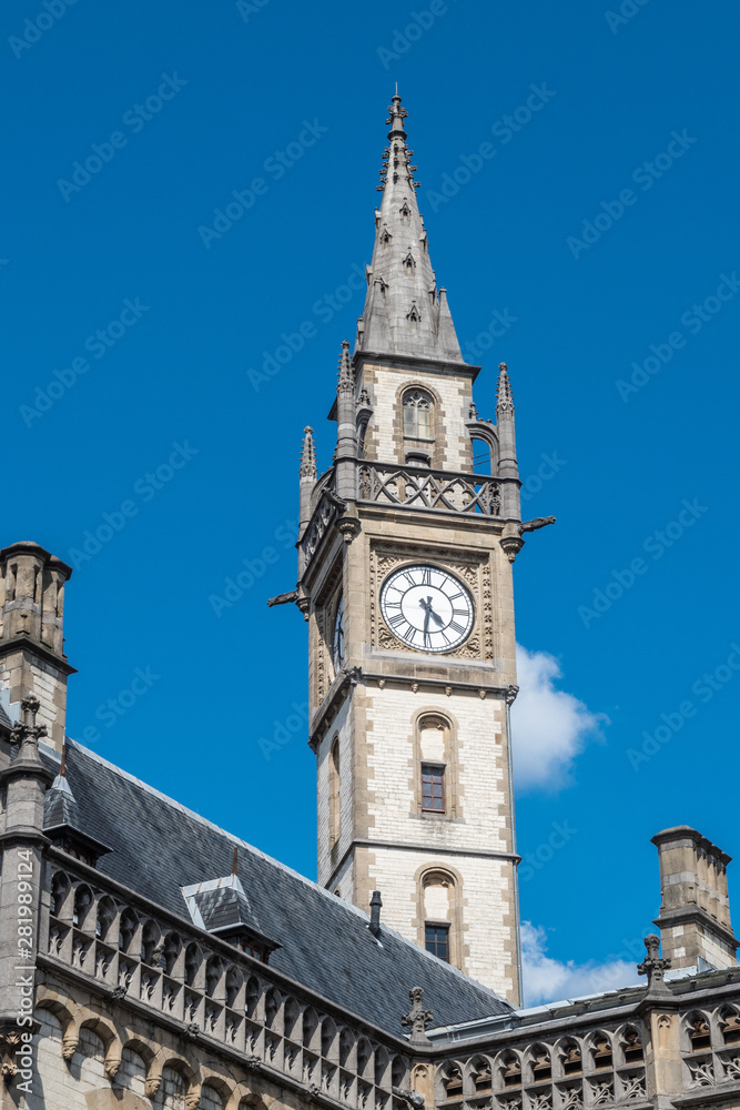 Gent, Flanders, Belgium -  June 21, 2019: Closeup of historic Postal Service clock tower against blue sky.