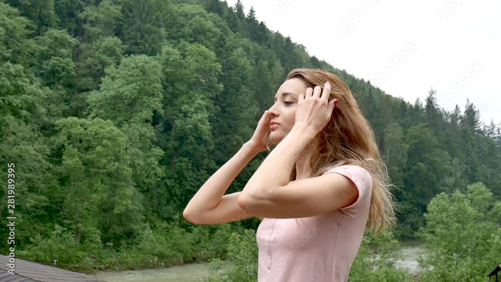 Happy curly girl in the mountains enjoys summer rain without an umbrella. The girl is happy and laughs cheerfully. beauty of nature Happy curly girl in the mountains enjoys summer rain without an umbrella. The girl is happy and laughs cheerfully. beauty of nature
