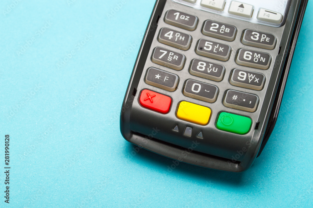 Credit card terminal on blue background. Close up of merchant  payment device, card machine.