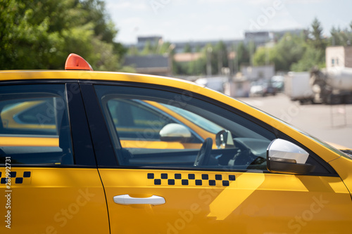 Photo of yellow taxi on street in summer
