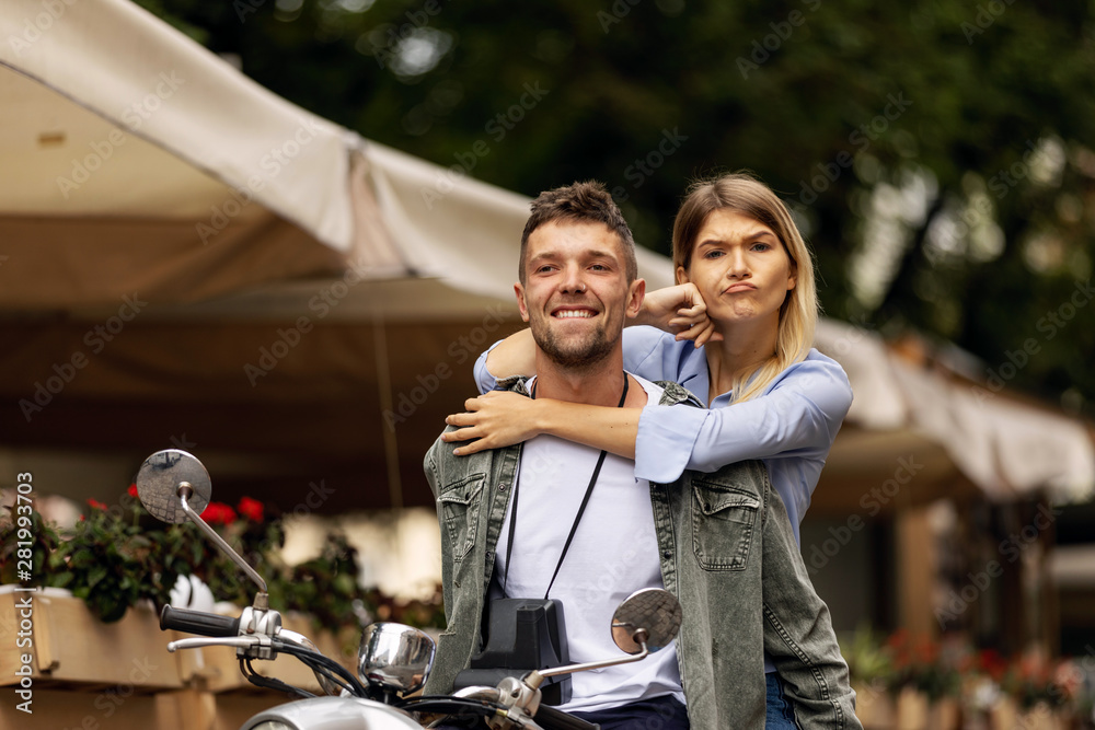 Happy couple of tourist travelers around city with motorbike scooter Happy couple of tourist travelers around city with motorbike scooter
