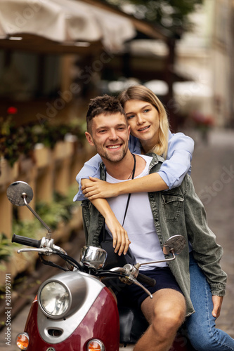 Happy couple of tourist travelers around city with motorbike scooter