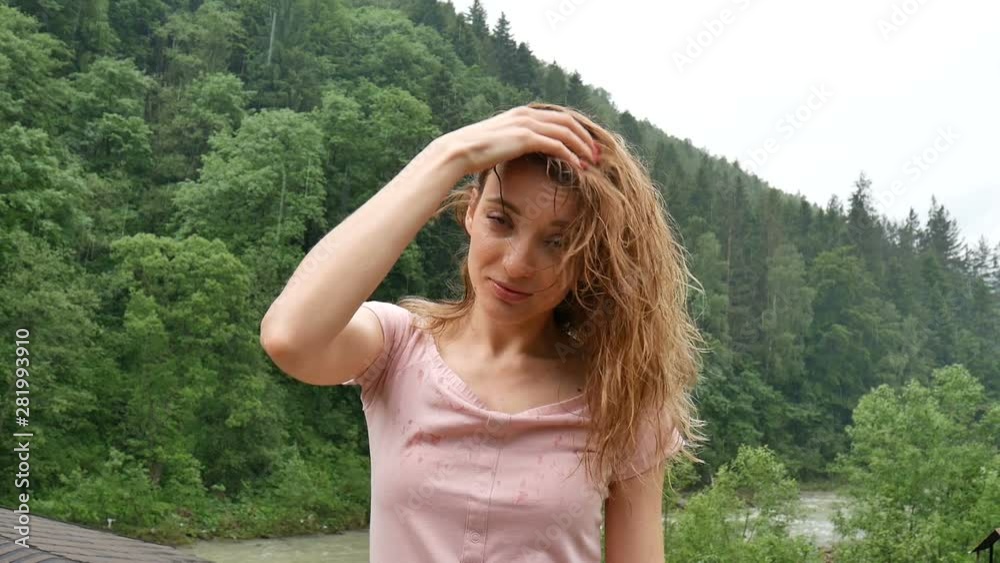 Happy curly girl in the mountains enjoys summer rain without an umbrella. The girl is happy and laughs cheerfully. beauty of nature Happy curly girl in the mountains enjoys summer rain without an umbrella. The girl is happy and laughs cheerfully. beauty of nature