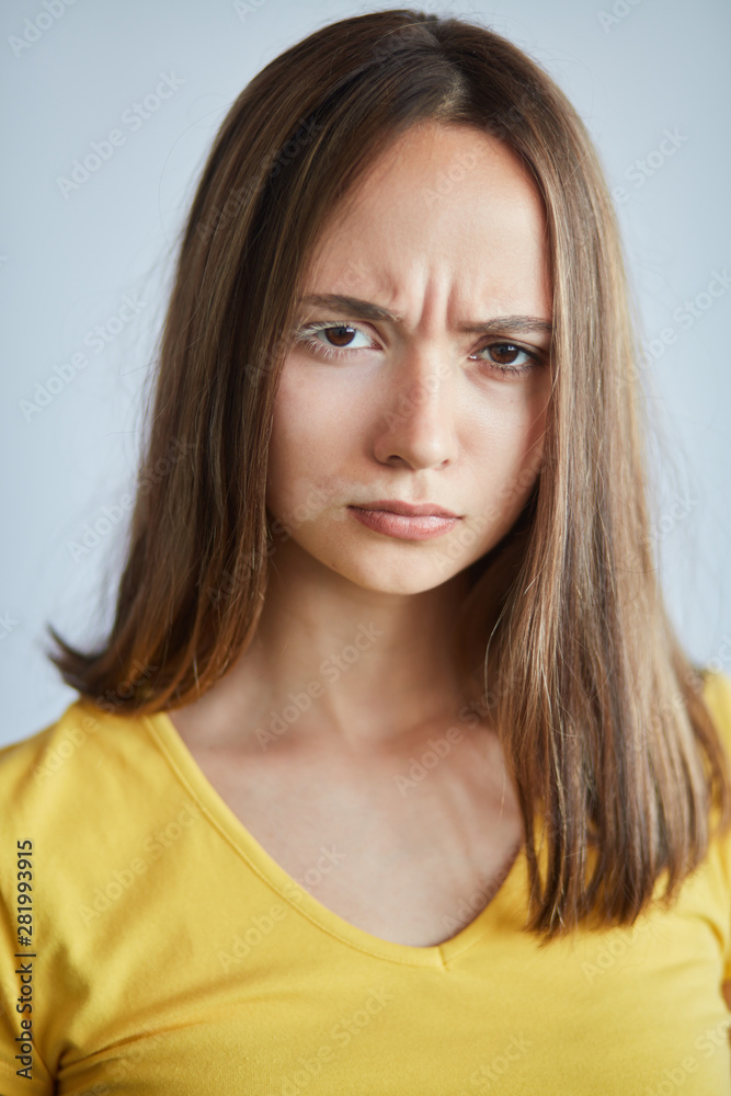 frowning serious girl isn't satisfied with hernface, close up portrait. anger concept. isolated white background frowning serious girl isn't satisfied with hernface, close up portrait. anger concept. isolated white background