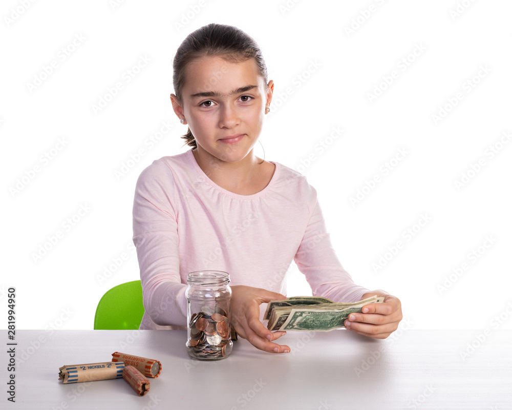 Girl playing and counting money from her glass piggy bank with copy space. Concept for business or teaching children for saving money. Girl playing and counting money from her glass piggy bank with copy space. Concept for business or teaching children for saving money.