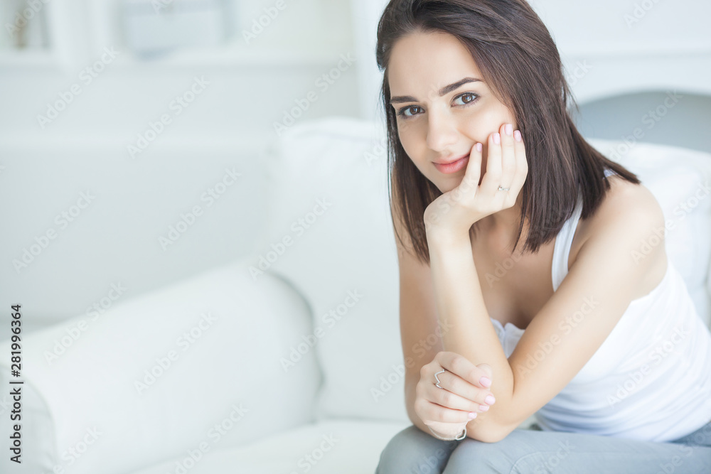 Portrait of young attractive brunette woman indoors. Beautiful lady on the couch. Female at the morning. Calm woman in weekend morning. Portrait of young attractive brunette woman indoors. Beautiful lady on the couch. Female at the morning. Calm woman in weekend morning.