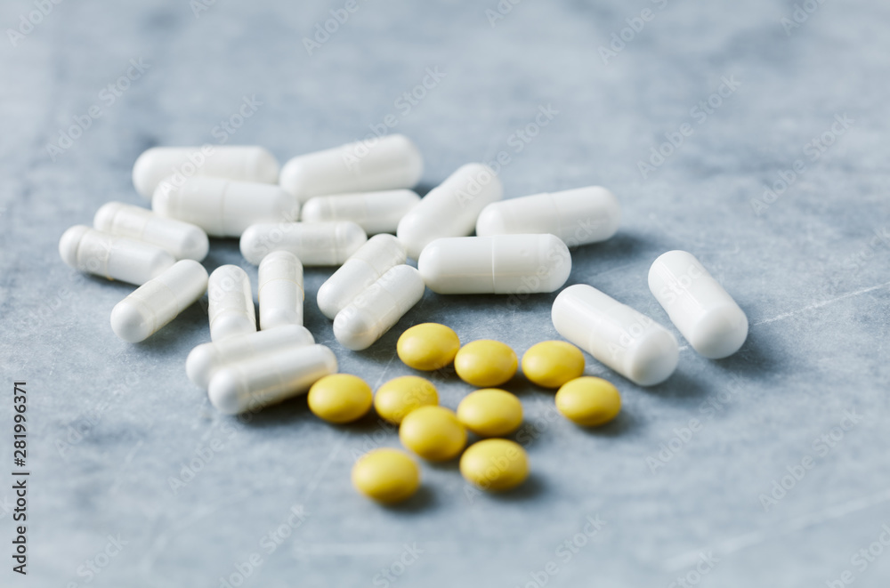 Proline and MSM (Sulfur) capsules and Vitamin C tablets to support collagen production. Bright stone background. Close up. Proline and MSM (Sulfur) capsules and Vitamin C tablets to support collagen production. Bright stone background. Close up.