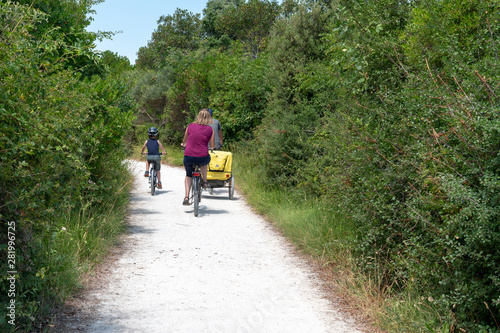 tourist family in bike during vacation mother father and children cycle trailer on the island of ile d'Aix Charente maritime