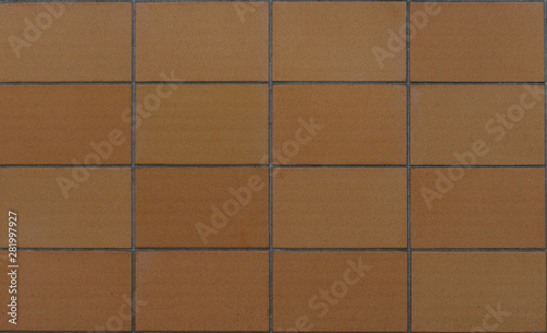 Texture of a wall build with big brown tiles