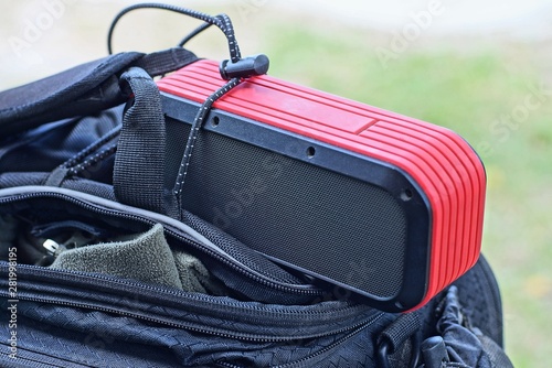 black red portable speaker lies on an open bag on the street © butus