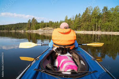 The owner and the dog in a life jacket floating in a kayak boat. © amarinchenko106