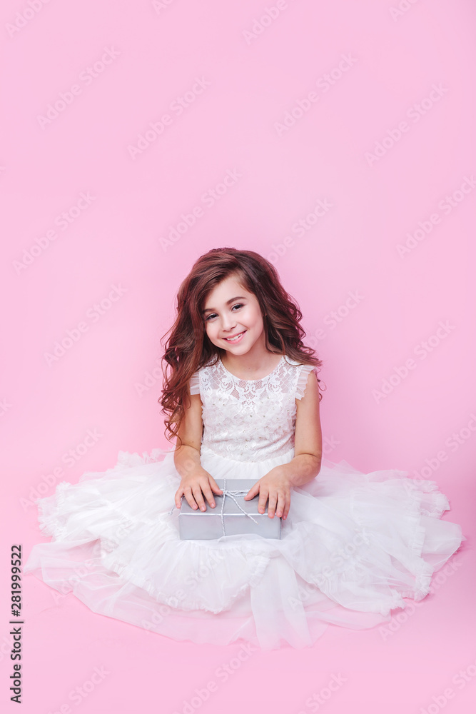 Little girl birthday studio portrait on pink wall girl opening present excited Little girl birthday studio portrait on pink wall girl opening present excited