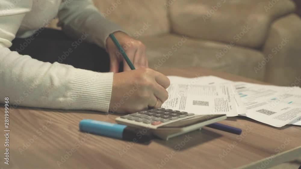 Close up woman making calculation on utility bills and credits. Hands ...