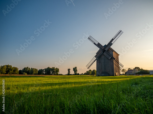 Old windmill on the green field.