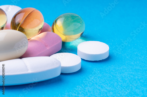 colored pills and multivitamins on a blue background. omega3 photo