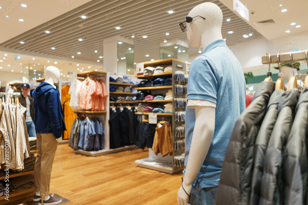 Trousers, a sweater and a hoodie on a hanger in a fashion store for youth. Trousers, a sweater and a hoodie on a hanger in a fashion store for youth.