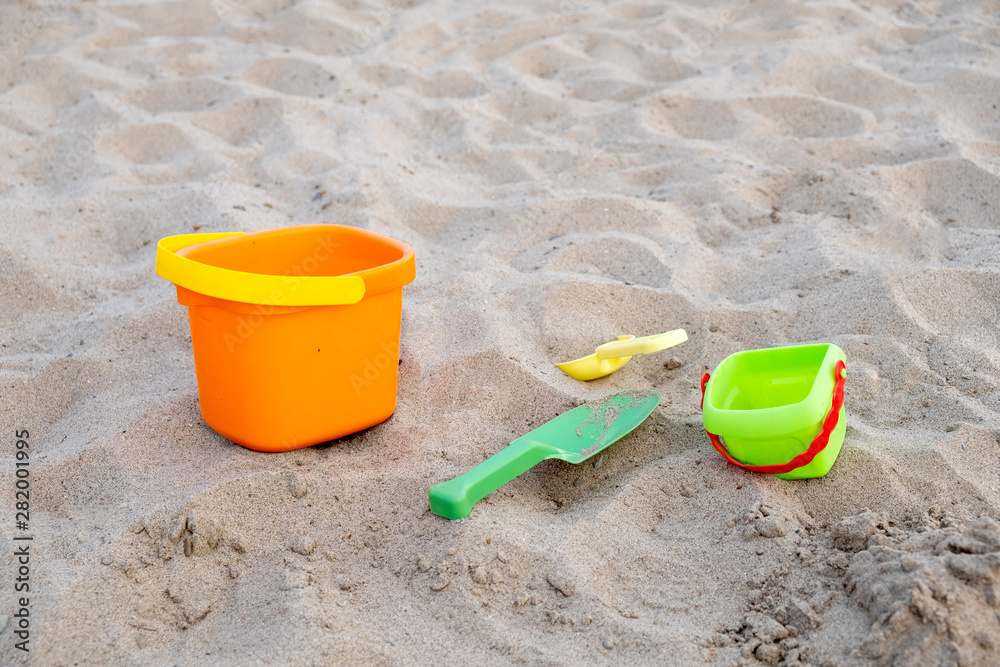 Children's toys lie on the sand on the beach. Family vacation on the beach. Children's toys lie on the sand on the beach. Family vacation on the beach.