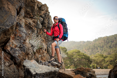 Tourist girl in sunglasses with backpack in mountains