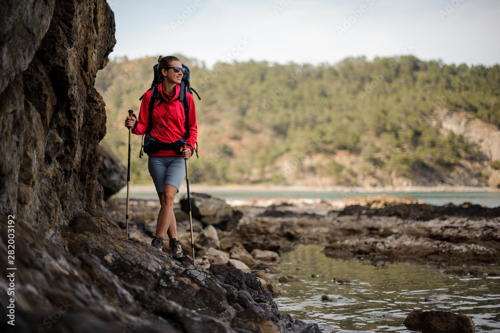 Obraz premium Female traveller walks in front of cliffs