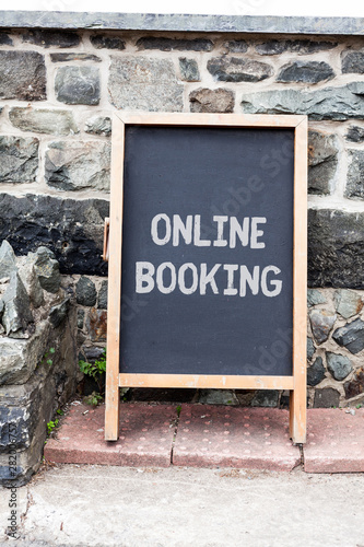 Handwriting text writing Online Booking. Conceptual photo Reservation through internet Hotel accommodation Plane ticket Empty black board with copy space for advertising. Blank dark board