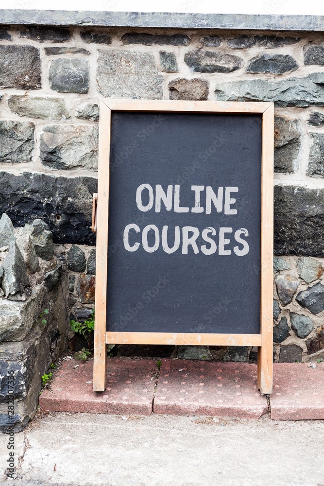 Fototapeta premium Handwriting text writing Online Courses. Conceptual photo Revolutionizing formal education Learning through internet Empty black board with copy space for advertising. Blank dark board