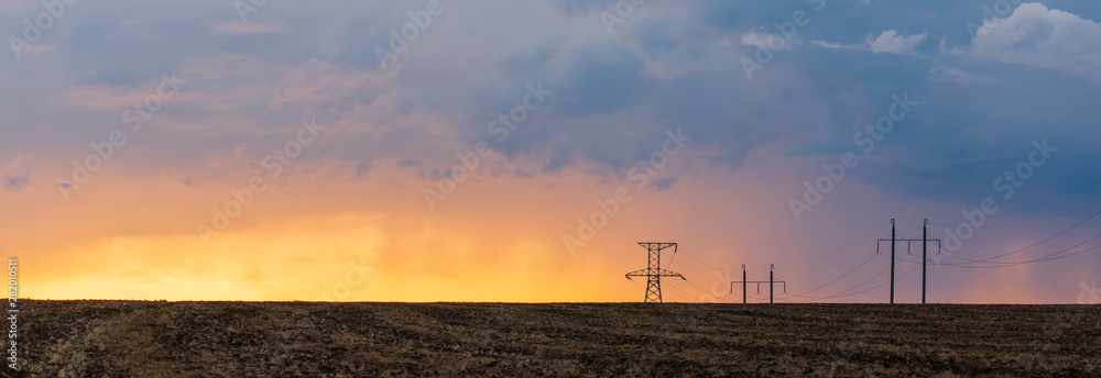 Epic sunset with rural landscape with high-voltage line