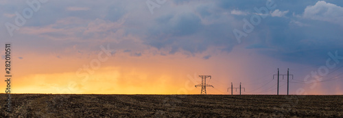 Obraz na płótnie Epic sunset with rural landscape with high-voltage line w salonie