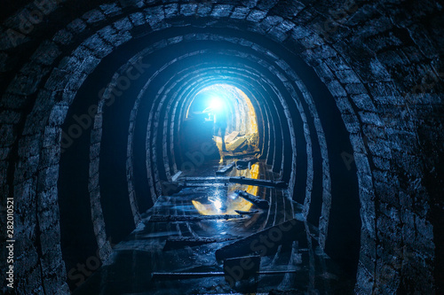 Dark creepy dirty flooded abandoned mine tunnel photo