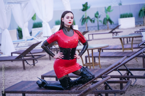 hot fashion woman in fetish latex rubber catsuit walk alone and have a rest
