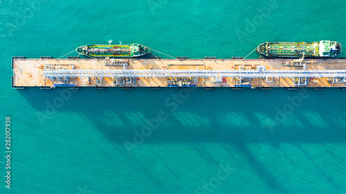 Aerial view tanker ship unloading at port, Business import export oil with tanker ship transportation oil from refinery on the sea.