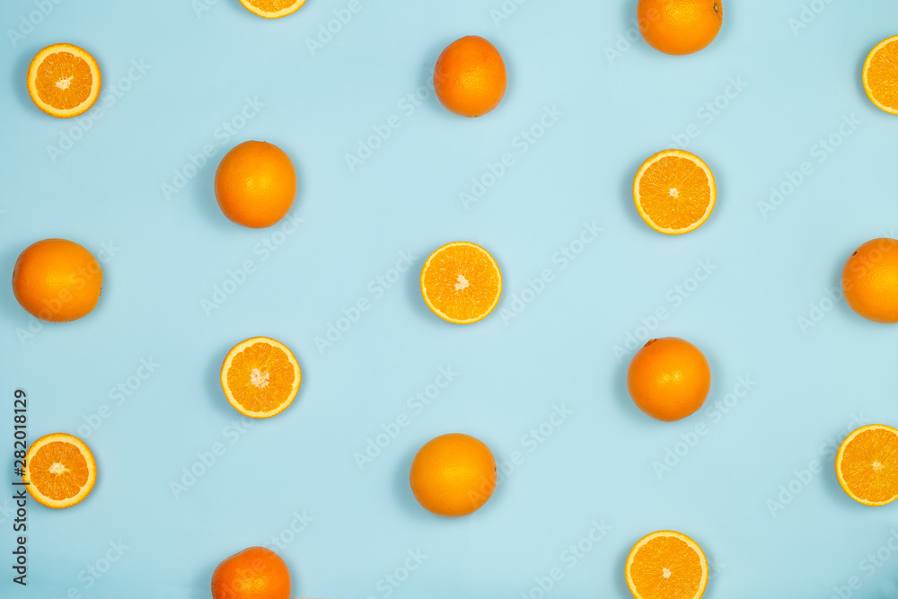 Oranges pattern with full and sliced oranges over a light blue background.