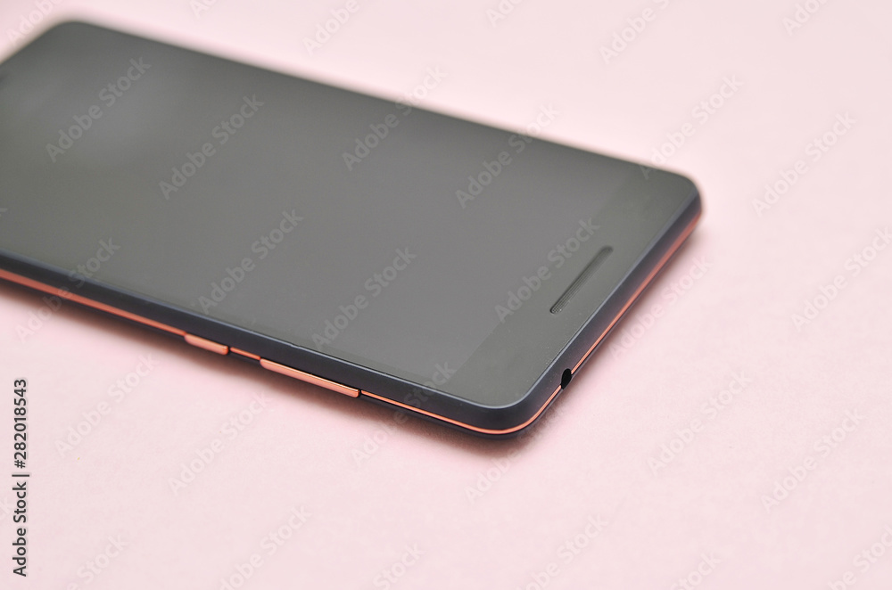 Black touch phone on blue background in neon light. Black touch phone on blue background in neon light.
