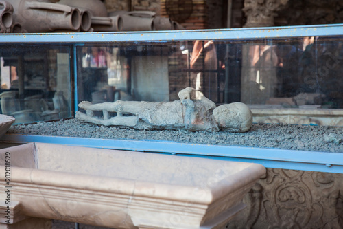 Plaster cast of a child and artifacts in the Forum Granary of the ancient city of Pompeii