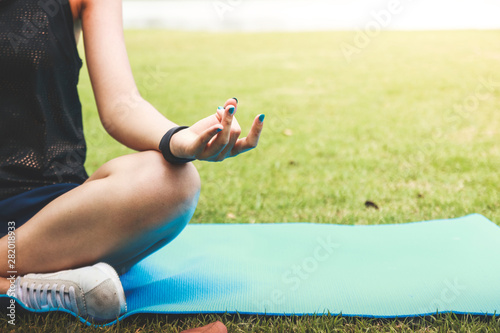 Woman Fitness Girl sitting and doing yoga in the park