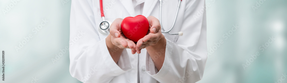 Doctor holding a red heart at hospital office. Medical health care and ...